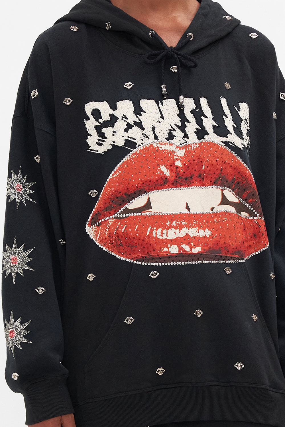 Detail view of model wearing CAMILLA black oversized hoodie in Chaos Magic print