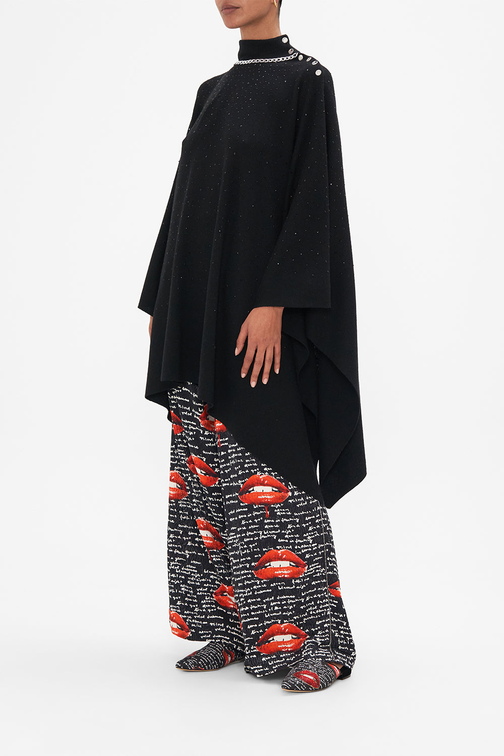 Side view of model wearing CAMILLA black knit poncho in Chaos Magic