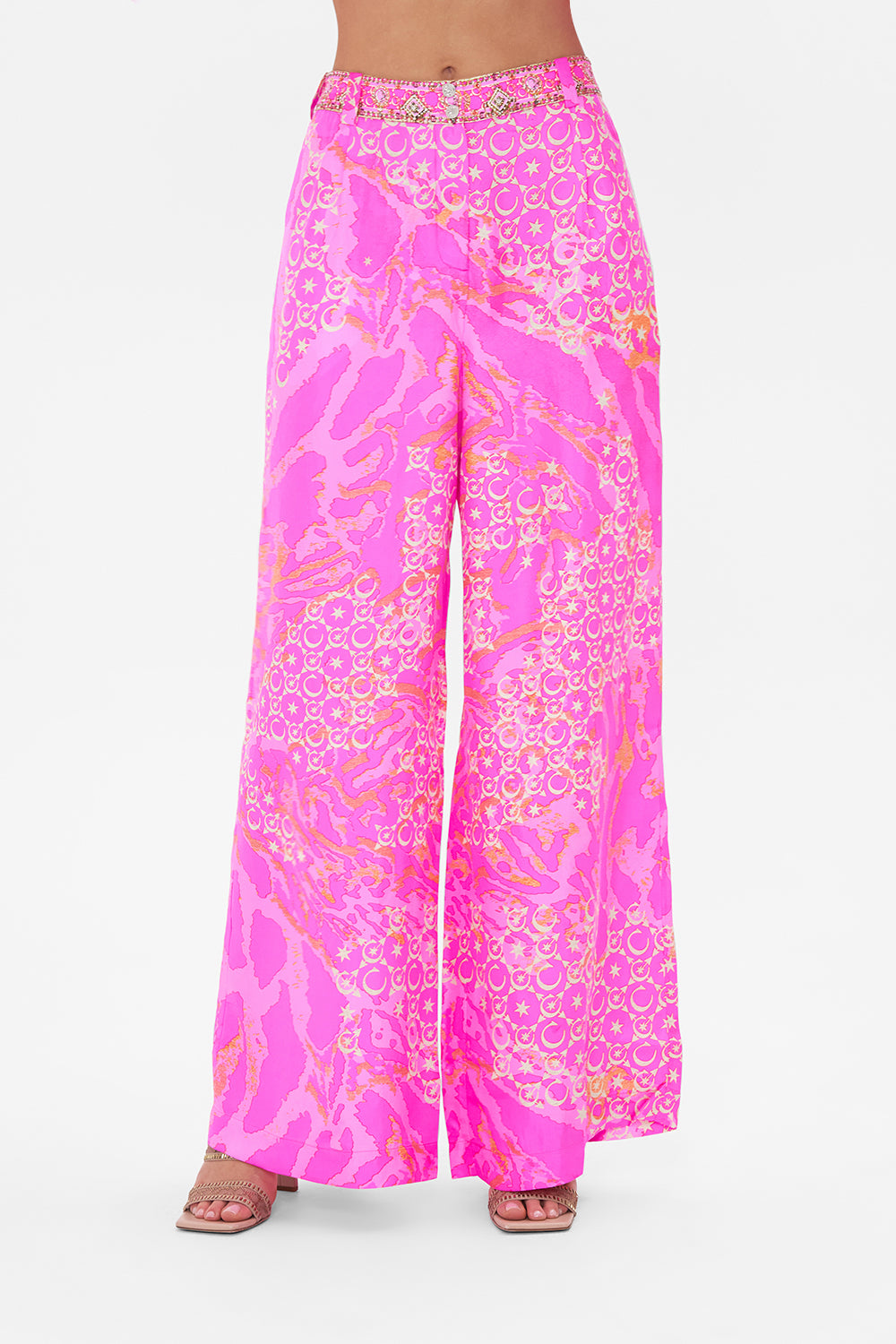 Crop view of model wearing CAMILLA silk pants in neon Song Of Sacrifice print