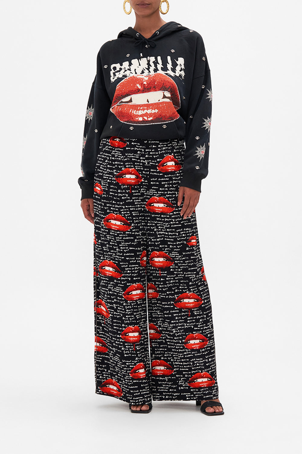 Front view of model wearing CAMILLA palazzo pants in black Chaos Magic print