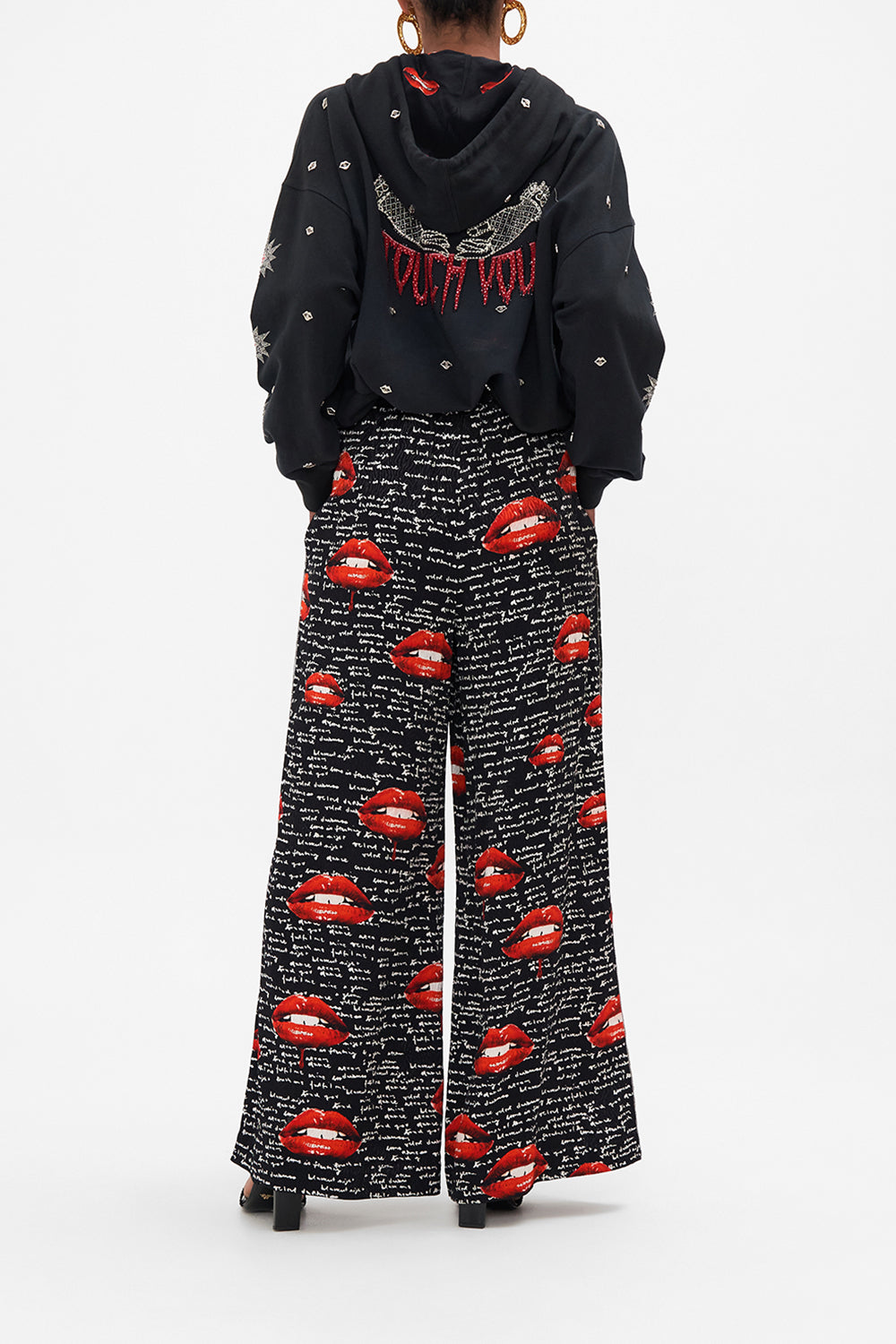 Back view of model wearing CAMILLA palazzo pants in black Chaos Magic print