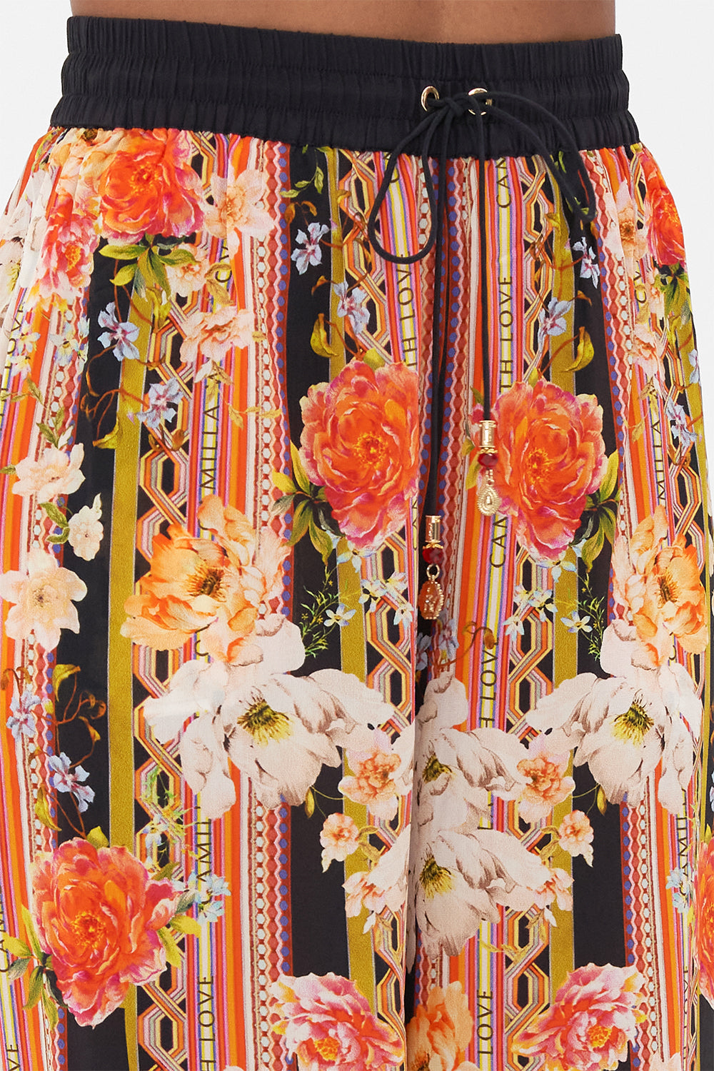 Detail view of model wearing CAMILLA floral silk pants in Secret History print