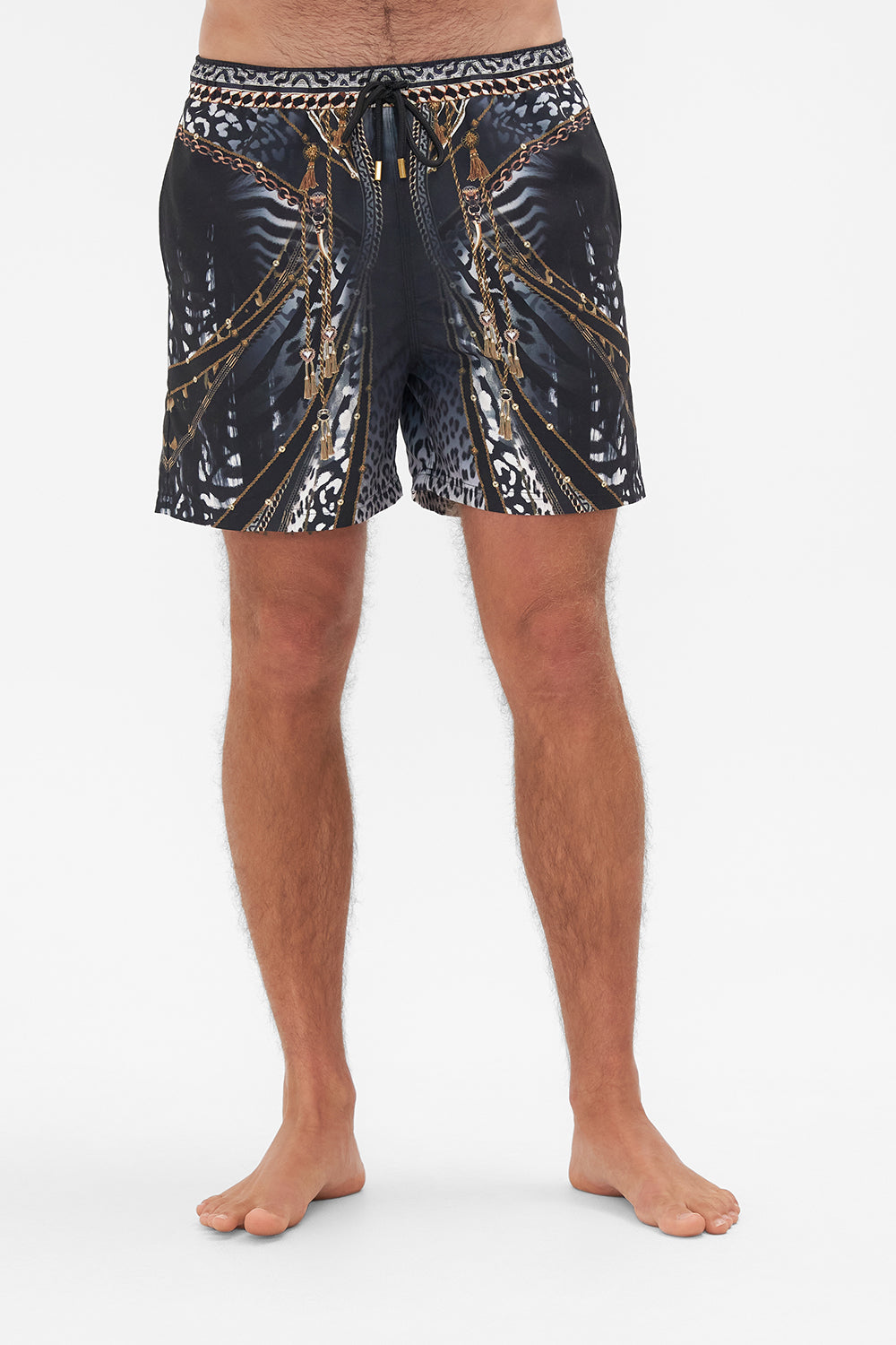 Crop view of model wearing Hotel Franks by CAMILLA mens black boardshorts in Untamed Royalty print