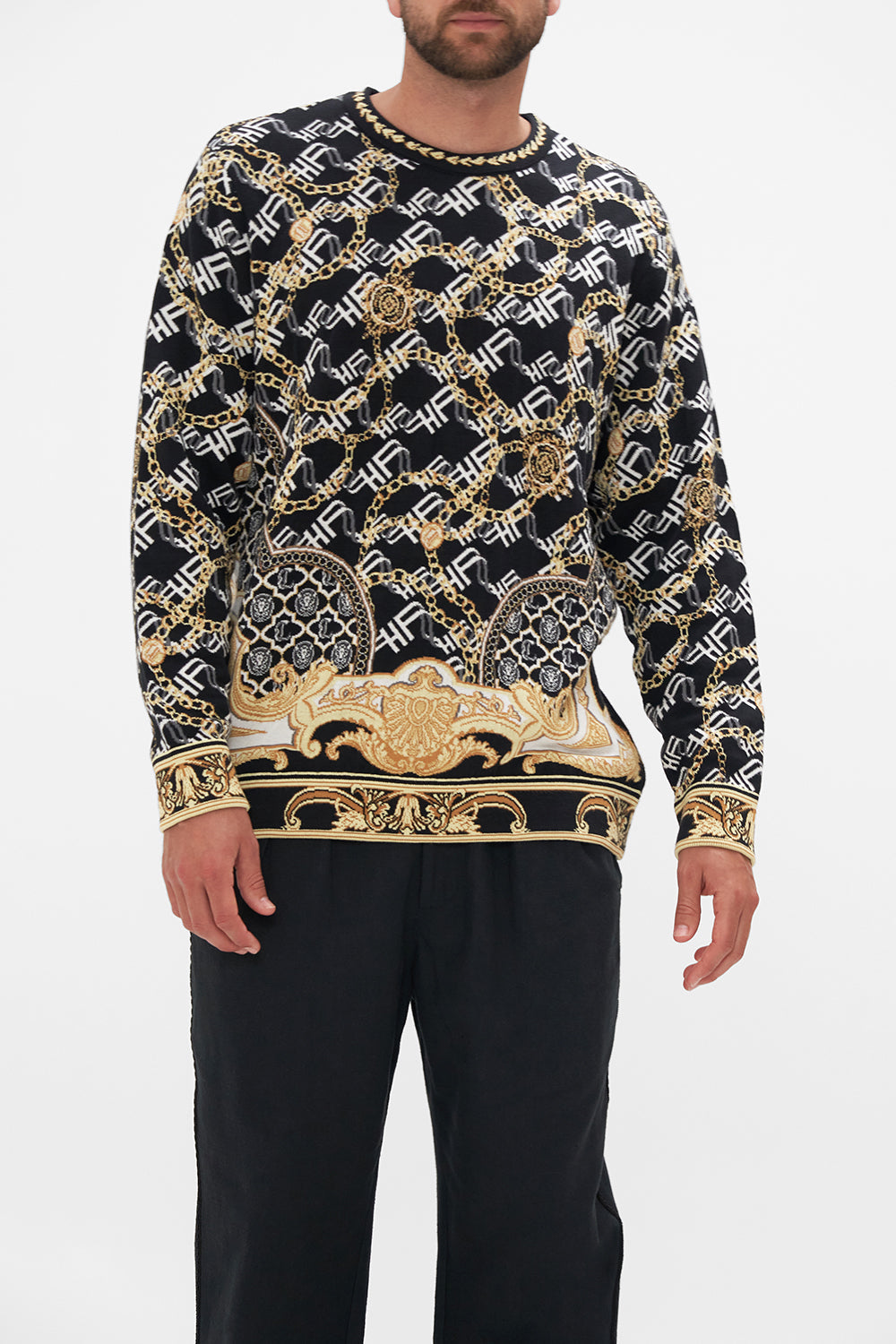 Crop view of model wearing Hotel Franks by CAMILLA mens oversized knit sweater in black and gold Tether Me Not print