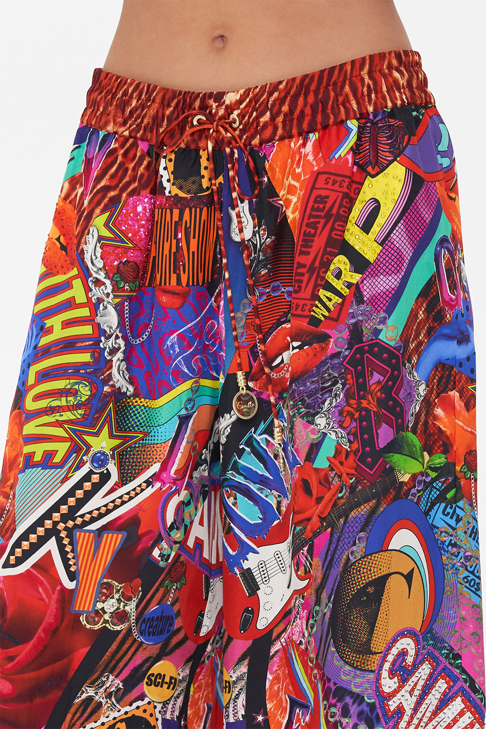 Detail view of model wearing CAMILLA silk palazzo pants in multicoloured Radical Rebirth print