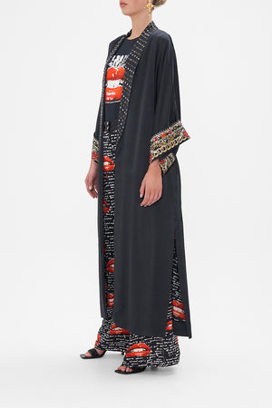 Side view of model wearing CAMILLA black silk robe in Radical Rebirth print