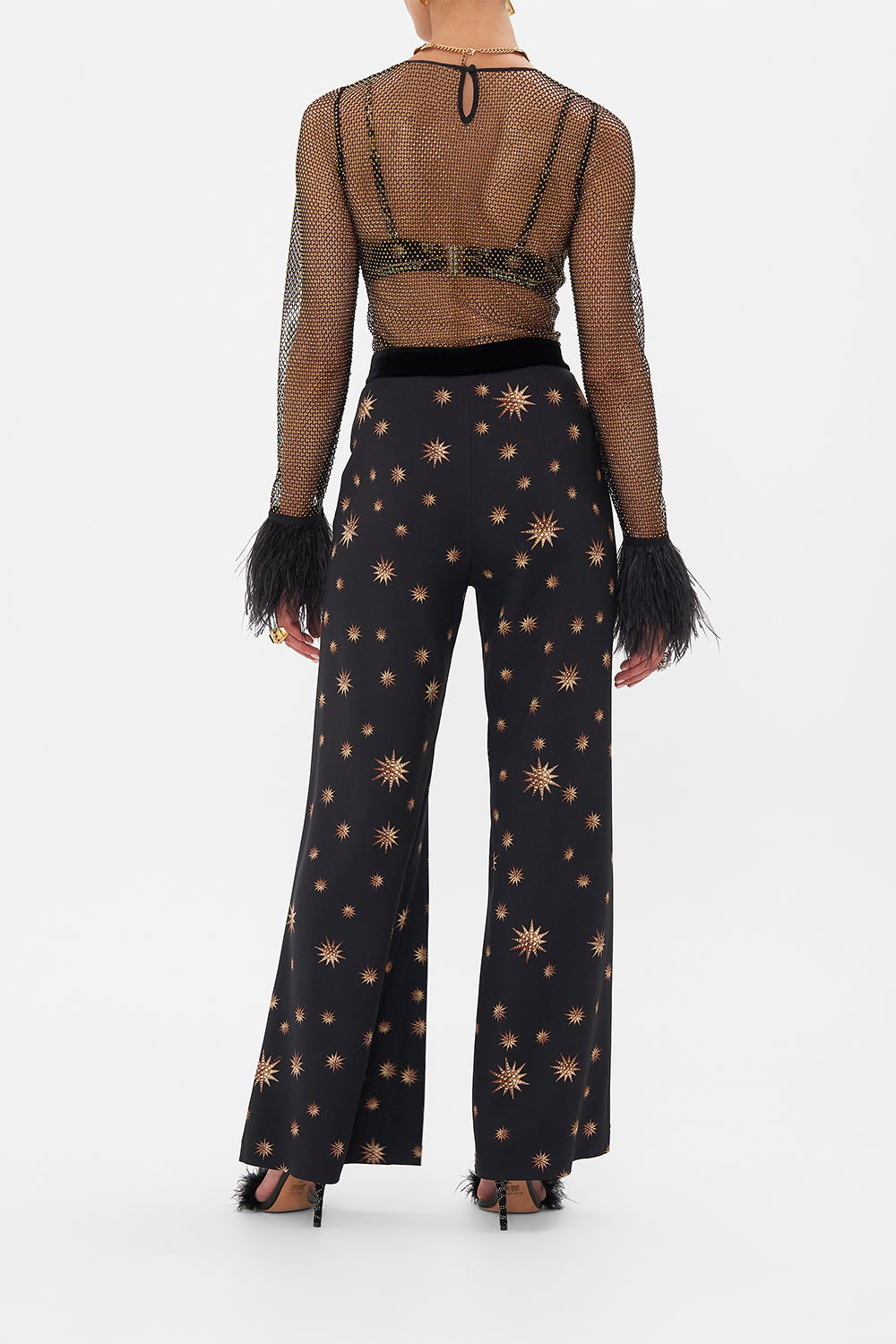 Back view of model wearing CAMILLAdesigner mesh top in Soul Of A Star Gazer print 