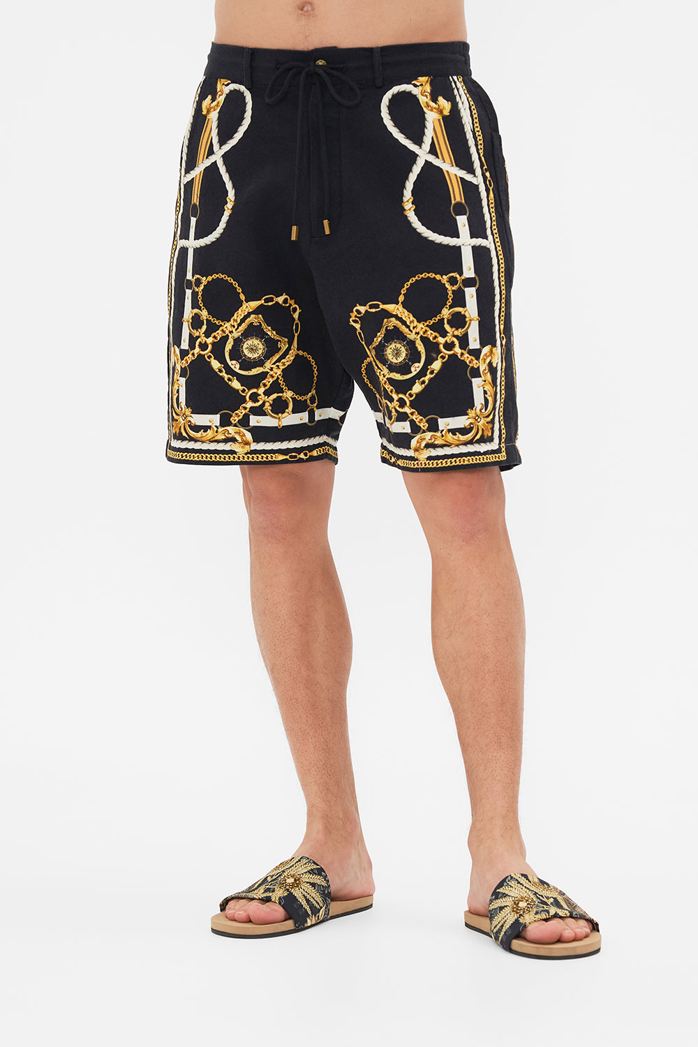 Crop view of model wearing Hotel Franks By CAMILLA mens boardshort in Coast To Coast print 
