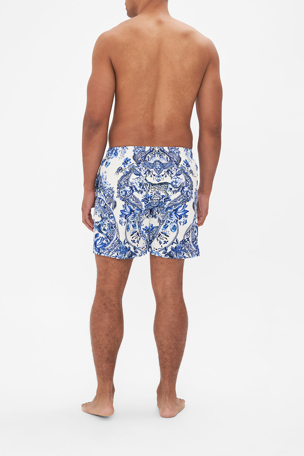 Back view of model wearing Hotel Franks By CAMILLA blue and white mens boardshorts in Glaze and Graze print