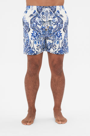 Crop view of model wearing Hotel Franks By CAMILLA blue and white mens boardshorts in Glaze and Graze print