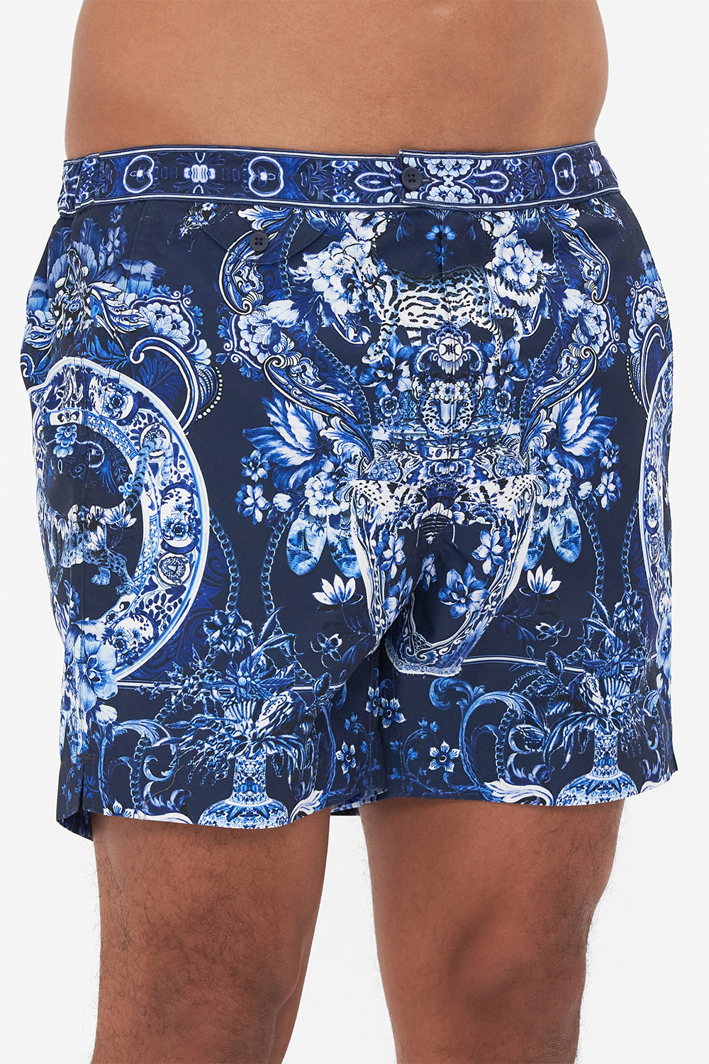 Detail view of model wearing Hotel Franks By CAMILLA mens blue swim shorts in Delft Dynasty print