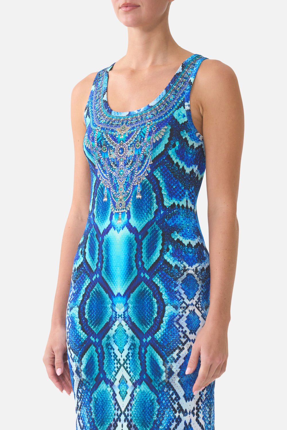 Woman wearing a blue patterned dress with intricate detailing on a white background