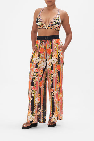 Front view of model wearing CAMILLA floral silk pants in Secret History print