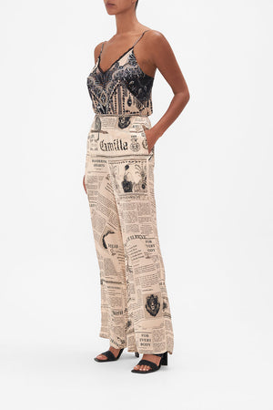 Side view of model wearing CAMILLA pink silk pants in Fame Fever print 